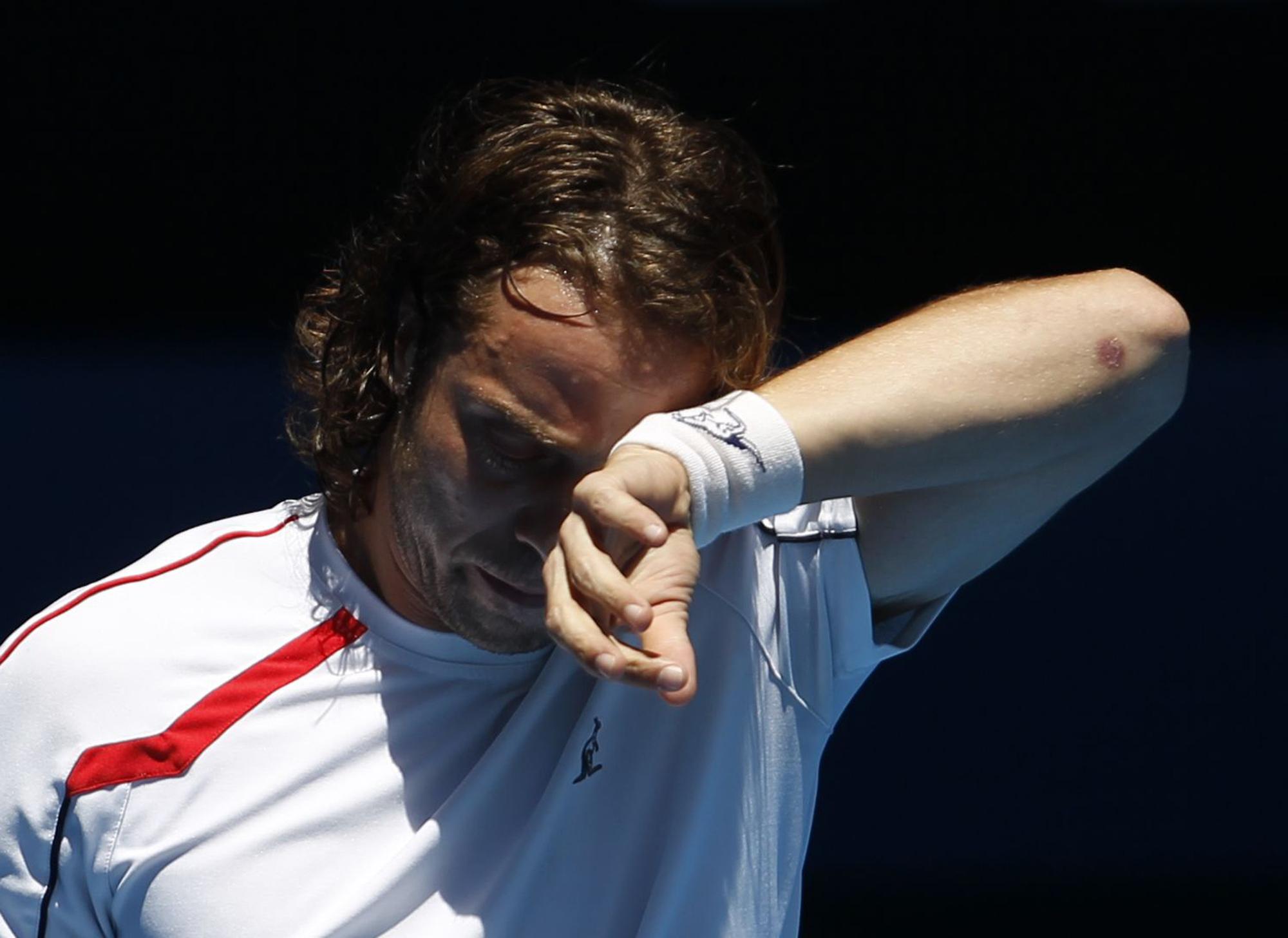 Paolo Lorenzi of Italy wipes perspiration from his forehead during his men's singles match against Novak Djokovic of Serbia at the Australian Open tennis tournament in Melbourne January 17, 2012. REUTERS/Tim Wimborne (AUSTRALIA - Tags: SPORT TENNIS) [REUTERS - Tim Wimborne]