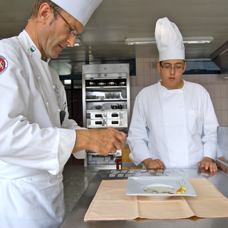 Dans une des salles de l’Ecole Professionnelle de Montreux, un apprenti cuisinier de 3e année soumet son potage au maître professionnel. [Antoine Droux]