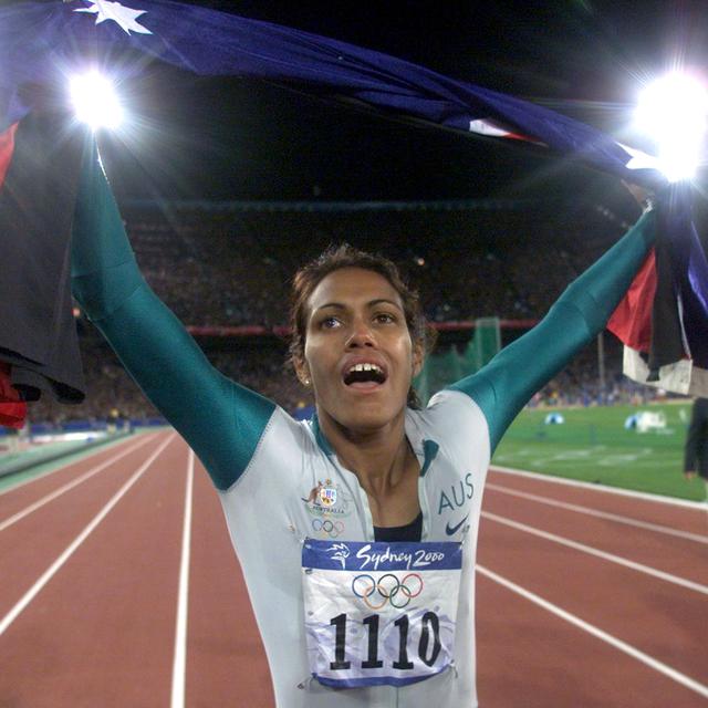Sydney 2000: l'Australienne Cathy Freeman effectue un tour d'honneur après sa victoire sur le 400 m des jeux Olympiques en brandissant deux drapeaux. Le drapeau australien et le drapeau aborigène, pour rappeler ses origines et tenter de réconcilier les descendants des européens et des aborigènes. [PB/JDP]
