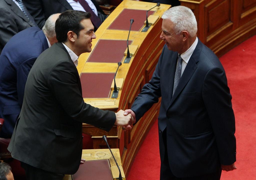 Le leader de la gauche radicale Alexis Tsipras salue le nouveau Premier ministre Panagiotis Pikramenos. [KEYSTONE - Thanassis Stavrakis]