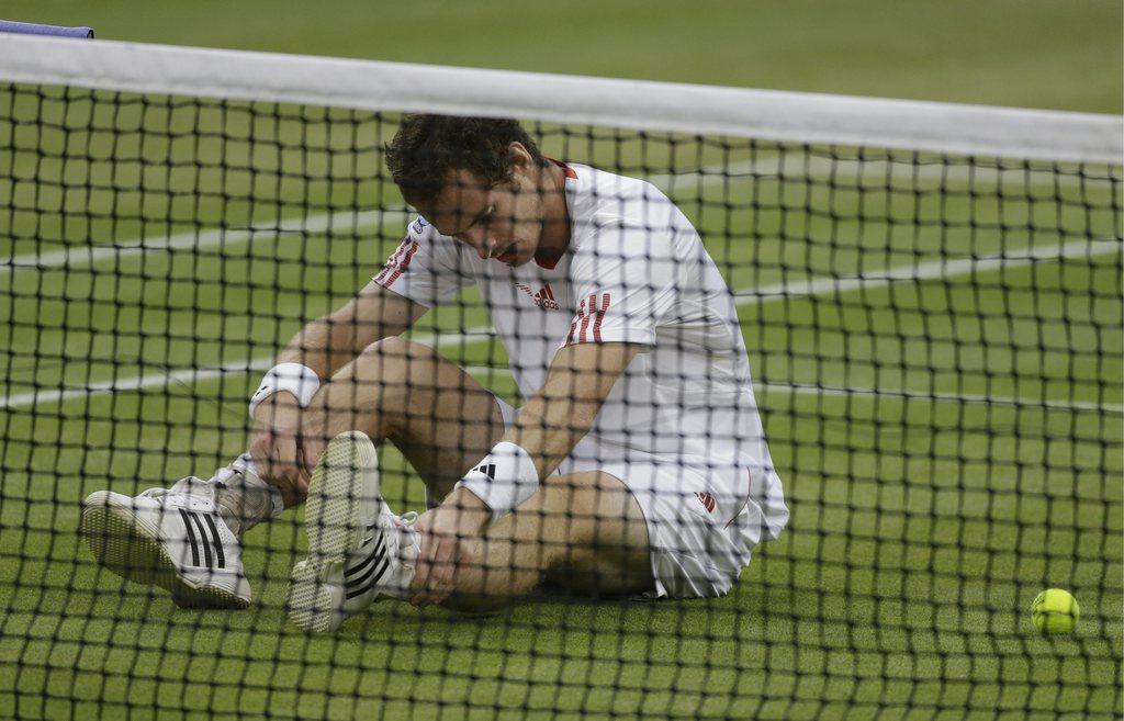 Andy Murray of Britain sits on the court after falling as he tried to play a return during the men's singles final match against Roger Federer of Switzerland at the All England Lawn Tennis Championships at Wimbledon, England, Sunday, July 8, 2012. (AP Photo/Anja Niedringhaus) [KEYSTONE - Anja Niedringhaus]