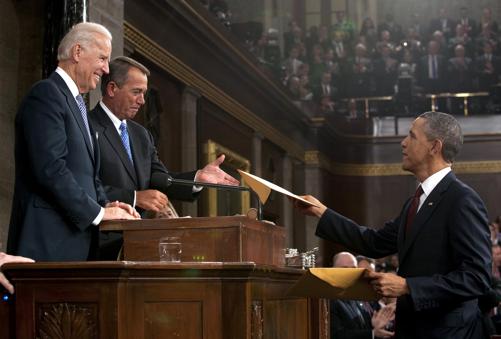 A la fin de son discours, Barack Obama a remis au Vice-président Joe Biden et au président de la Chambre des représentants John Boehner une copie de son discours. [REUTERS - Saul Loeb]