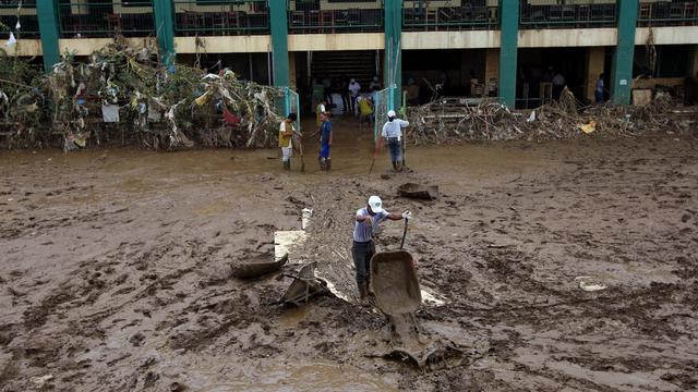 Dimanche 12 août: des Philippins de la localité de Marikina, à l'est de la capitale Manille, s'activent à évacuer la boue d'une école ravagée par les intempéries et les inondations. [Rolex de la Pena]