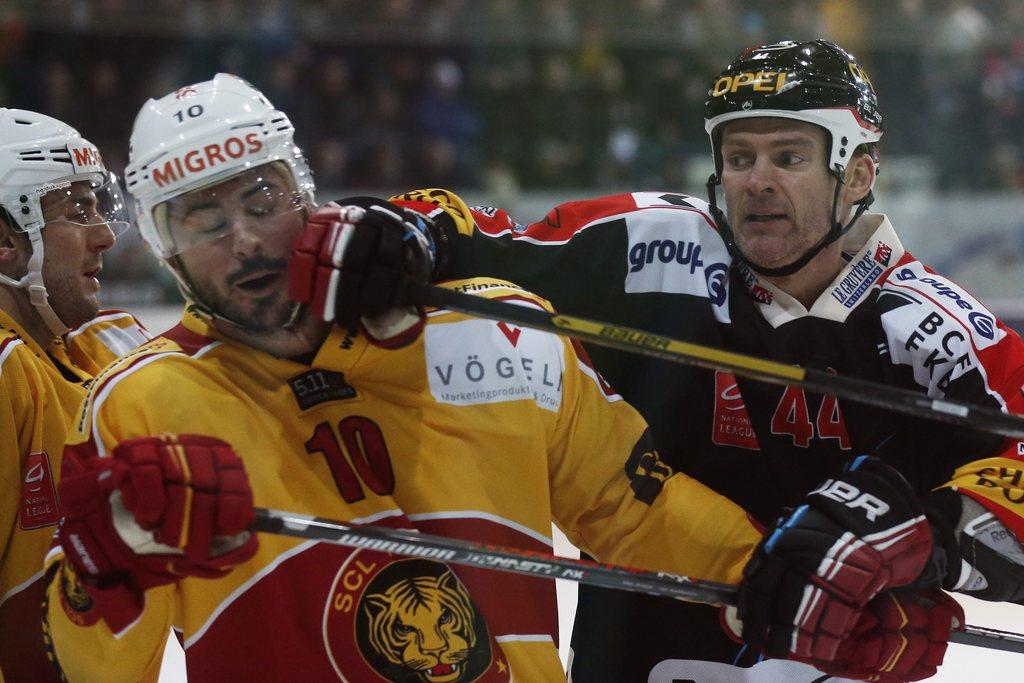 Fribourgs Shawn Heins schlaegt Langnaus Pascal Pelletier ins Gesicht im Meisterschaftsspiel der National League A zwischen dem HC Fribourg-Gotteron und den SCL Tigers am Samstag, 26. Januar 2013 in der BCF-Arena in Fribourg. [Peter Klaunzer]