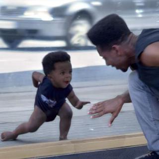 Dans la publicité Evian "Baby&Me", des adultes dansent devant une vitrine et la caméra montre leur reflet en bébé. [DR]