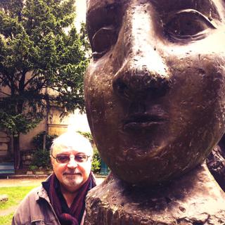 Raphaël Aubert à côté du portrait de Dora Maar, sculpture de Picasso, Monument à Guillaume Apollinaire, Paris.