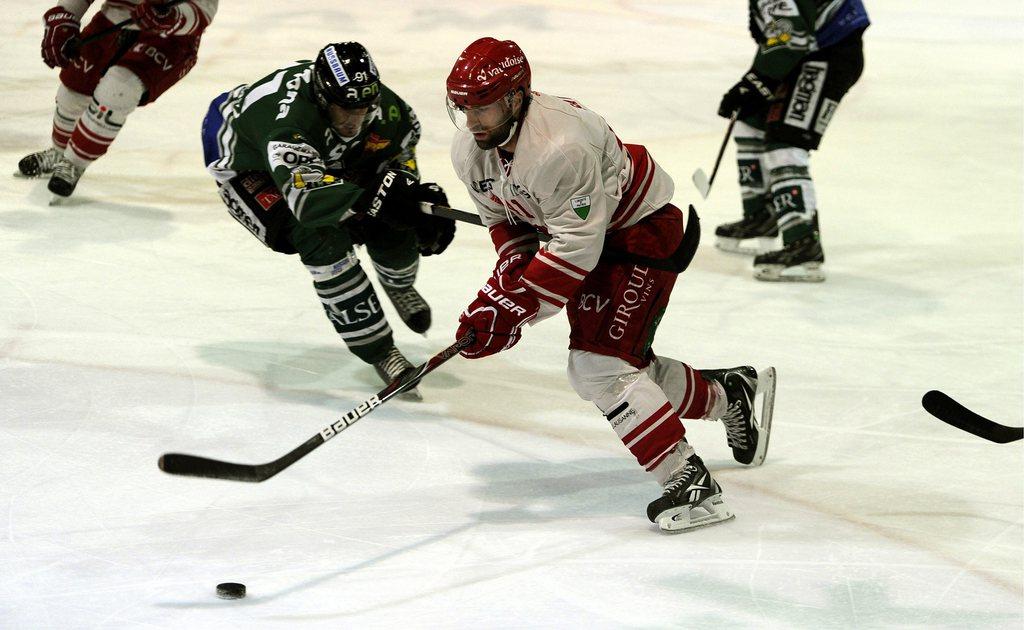 Paul Savary  (en blanc, ici face à Romano Pargaetzi) et le Lausanne HC sont près du sacre en LNB. [Sigi Tischler]