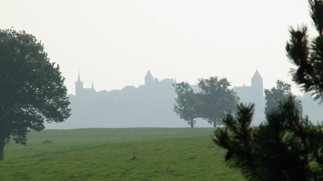 La silhouette brumeuse de Romont (FR) au petit matin. [Catherine Crevoisier Boyer]