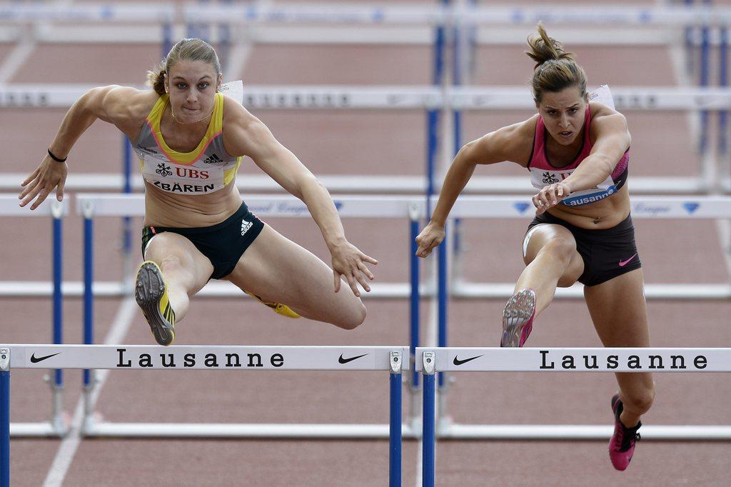 Noemi Zbären (à g.) et Clelia Reuse (à dr.) à la lutte dans le 100m haies. [KEYSTONE - JEAN-CHRISTOPHE BOTT]