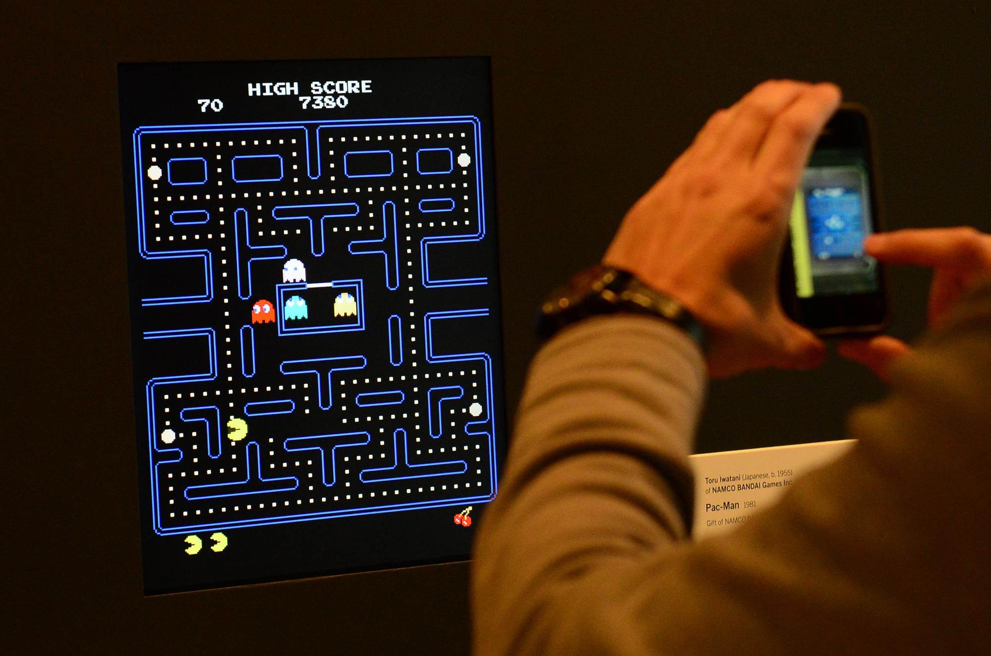 A côté de Pac-Man (1980), est exposé un vaste graphique de son code. [AFP - EMMANUEL DUNAND]
