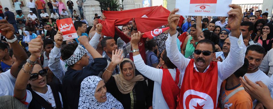 Un manifestant tunisien brandit une pancarte invitant le gouvernement à démissionner, le 23 octobre 2013. [Fethi Belaid]