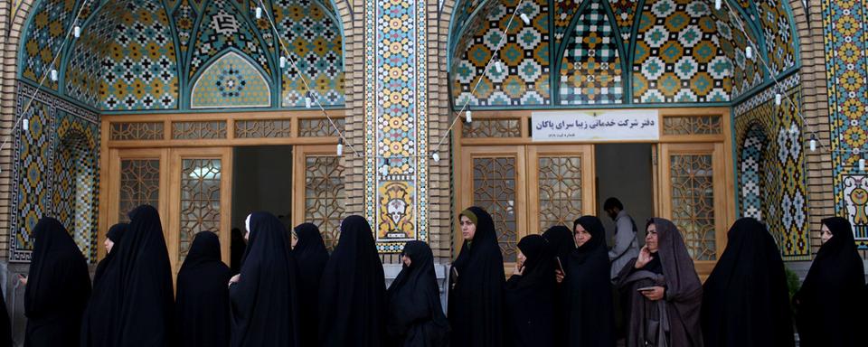 Vendredi 14 juin: des Iraniennes attendent de voter à Qom le jour de l'élection présidentielle. [AP/Keystone - Ebrahim Noroozi]