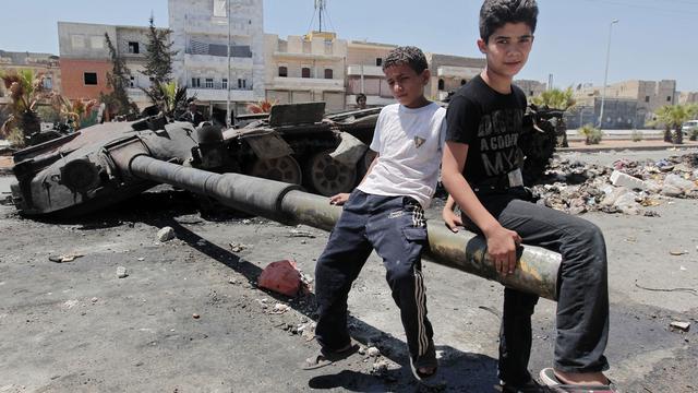 Enfants syriens jouant avec les restes d'un tank, Alep le 3 août 2012. [Ahmad Gharabli]
