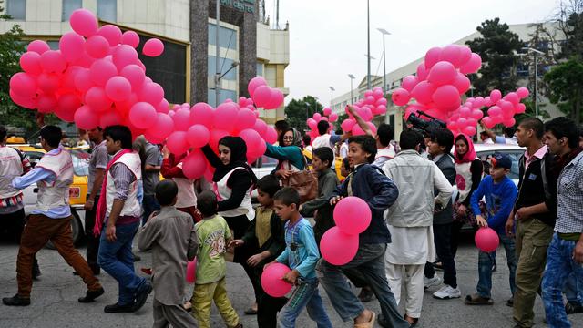 Des bénévoles afghans distribuent des ballons roses dans les rues de Kaboul. [Massoud HOSSAINI]