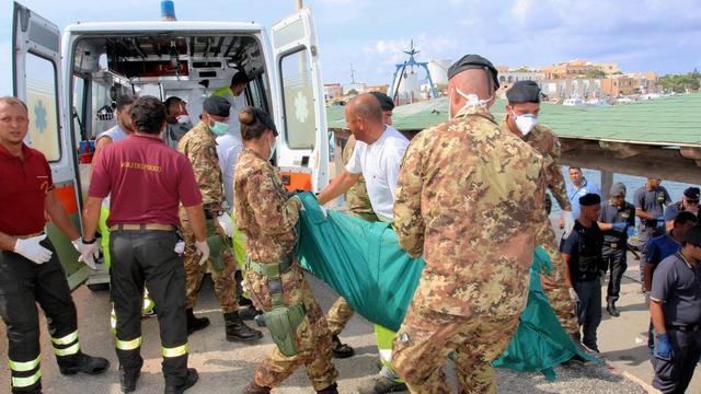 Des militaires italiens évacuent des corps retrouvés dans l'épave de l'embarcation. [EPA/ARMY PRESS OFFICE]