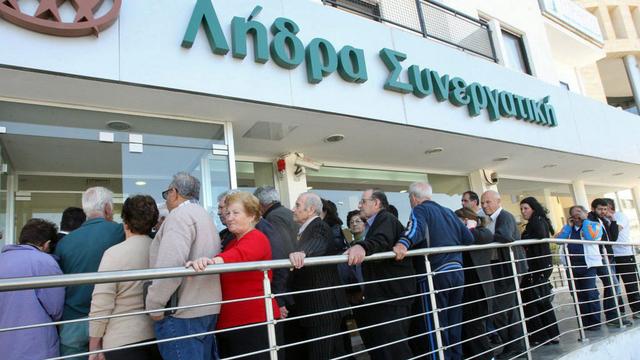 Les Chypriotes ont fait la queue par dizaines dans le calme jeudi devant les banques du pays. [EPA/STR/Keystone]