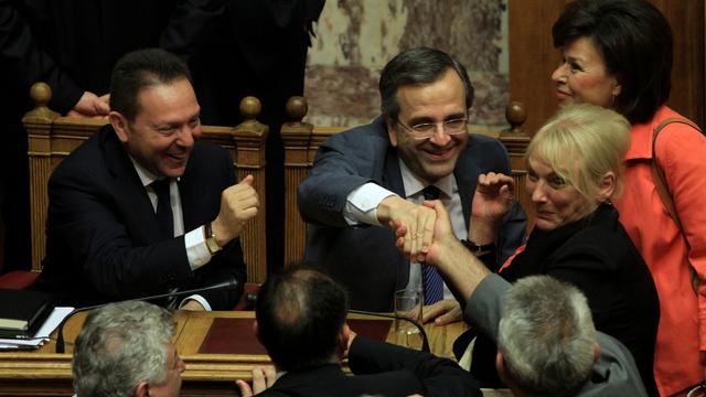 Le ministre grec des Finances Yannis Stournaras et le Premier ministre Antonis Samaras ont été félicités par les législateurs après le vote du Parlement à Athènes mercredi. [FOSPHOTOS]