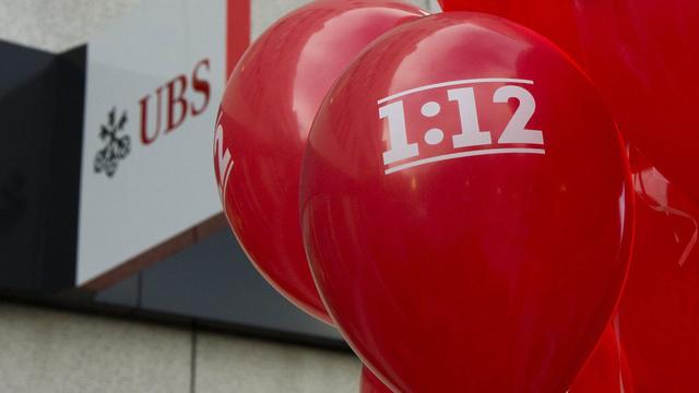 Des ballons aux couleurs de l'initiative 1:12 sont accrochés devant le logo de la banque UBS lors du lancement de la campagne sur l'initiative 1:12 dans les cantons romands ce jeudi 17 octobre 2013 devant le siege UBS à Sion. [Jean-Christophe Bott]
