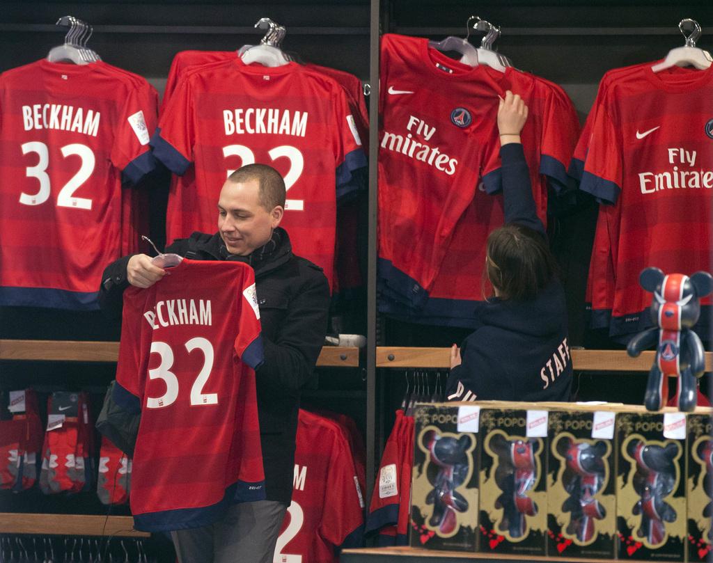 A man looks at a soccer shirt on display with the name of British soccer player David Beckham, at the the Club's shop on the Champs Elysees, in Paris, Friday, Feb. 1, 2013. The jersey is on sale for euros 110 ($150). David Beckham lit up a subdued transfer deadline day in Europe by securing perhaps the final move of his globetrotting career, a surprise short-term deal with ambitious French club Paris Saint-Germain. (AP Photo/Michel Euler) [Michel Euler]