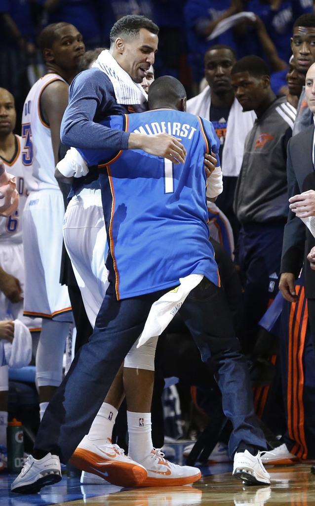 Larry Hill, right, of Oklahoma City, celebrates with Oklahoma City Thunder guard Thabo Sefolosha, left, after he nailed a half-court shot to win $20,000 in the break after the third quarter of Game 1 of a first-round NBA basketball playoff series between the Oklahoma City Thunder and the Houston Rockets in Oklahoma City, Sunday, April 21, 2013. Oklahoma City won 120-91. (AP Photo/Sue Ogrocki) [KEYSTONE - Sue Ogrocki]