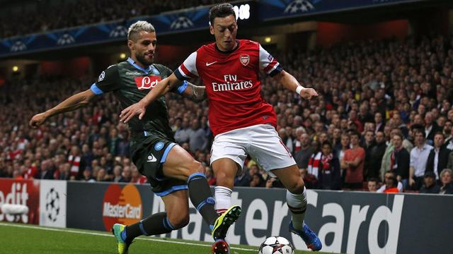 L'arrivée de Mesut Ozil (en rouge, ici "chargé par Valon Behrami) a transformé Arsenal. [Matt Dunham]