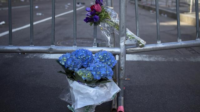 Des fleurs ont été déposées devant les barricades disposées pour empêcher d'accéder à la scène du drame. [Shannon Stapleton]