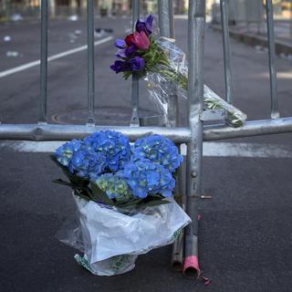 Des fleurs ont été déposées devant les barricades disposées pour empêcher d'accéder à la scène du drame. [Shannon Stapleton]