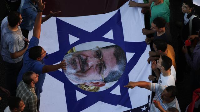 Une photo de Mohammed Morsi au centre d'un drapeau israélien. [Hassan Ammar]
