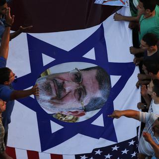 Une photo de Mohammed Morsi au centre d'un drapeau israélien. [Hassan Ammar]