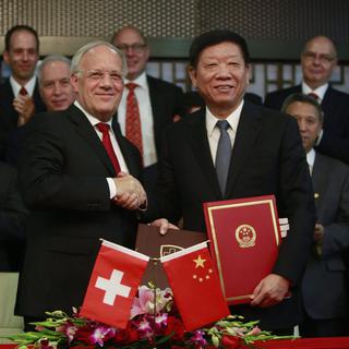 Les ministres Johann Schneider-Ammann et Yin Weimin ont signé l'accord ce samedi à Pékin. [EPA / Keystone - How Hwee Young]
