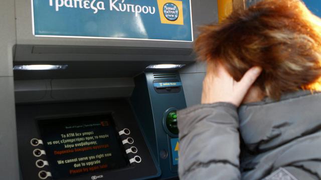 Une femme essaie de retirer de l'argent d'un distributeur de billets à Chypre. [Katja Christodoulou]