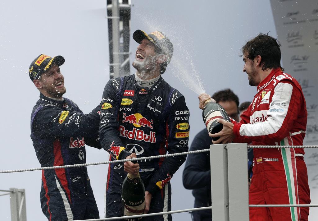 Vettel (g.) et Alonso (d.) ont fêté le héros du jour comme il se doit. [KEYSTONE - Silvia Izquierdo]