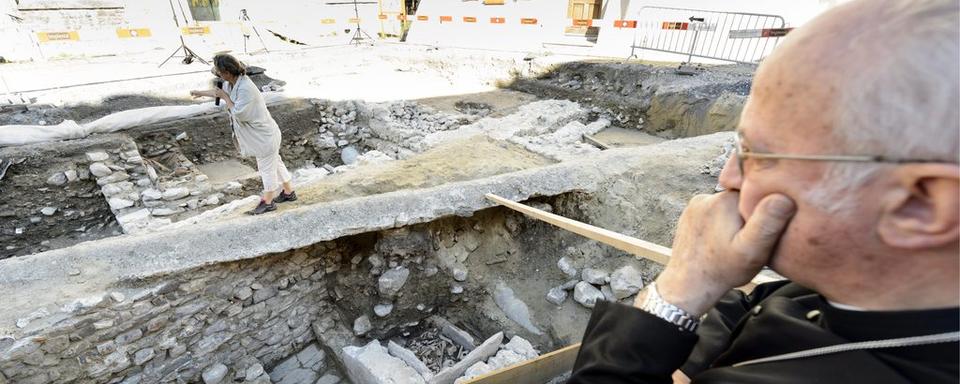 Monseigneur Joseph Roduit, abbé de Saint-Maurice, observe les vestiges d'une église et de ses tombes découvertes devant l'Abbaye de St-Maurice. [Laurent Gillieron]