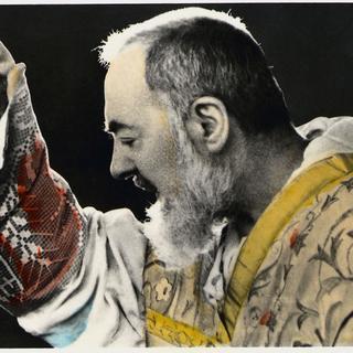 Portrait de Padre Pio pendant une messe en 1959. La main qui bénit laisse voir le stigmate. [Leemage / AFP]