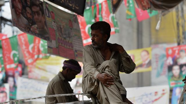 Des hommes entourés d'affiches électorales à Lahore, le 10 mai 2013.