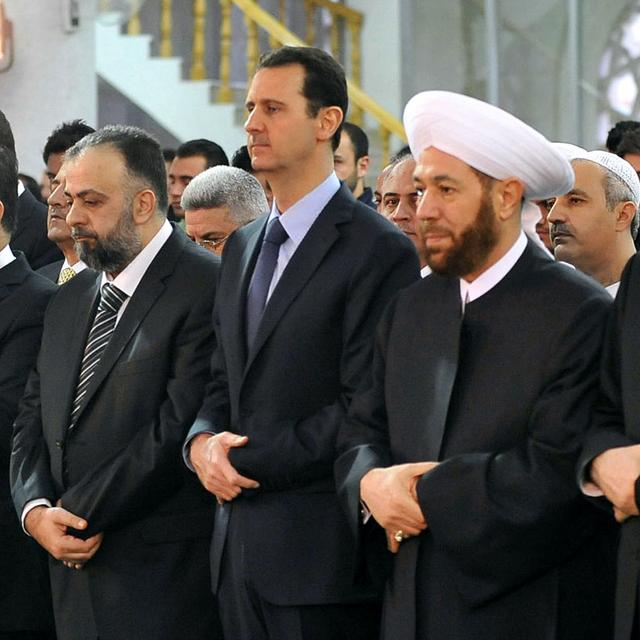 Le président Bashar al-Assad et le Grand Moufti Ahmed Hassun (à sa gauche) priant dans une mosquée de Damas. [Sana / AFP]