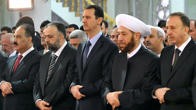 Le président Bashar al-Assad et le Grand Moufti Ahmed Hassun (à sa gauche) priant dans une mosquée de Damas. [Sana / AFP]