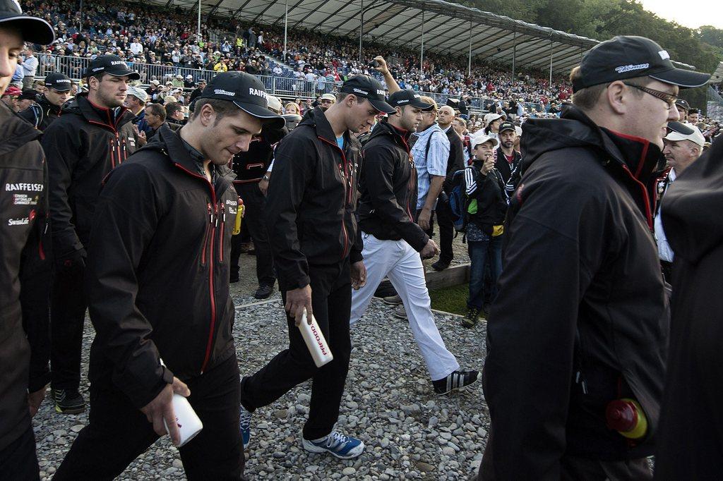 Le roi en titre Kilian Wenger (au centre) rentre dans l'arène avec sa délégation. [KEYSTONE - PETER SCHNEIDER]