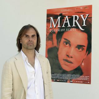 Le réalisateur Thomas Imbach posant devant l'affiche de son film. [Urs Flueeler]