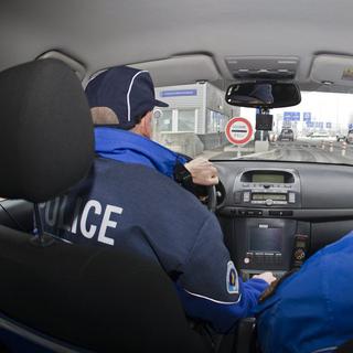 Policiers genevois (à gauche) et français à la frontière, lors d'une patrouille mixte en 2009. [Salvatore Di Nolfi]