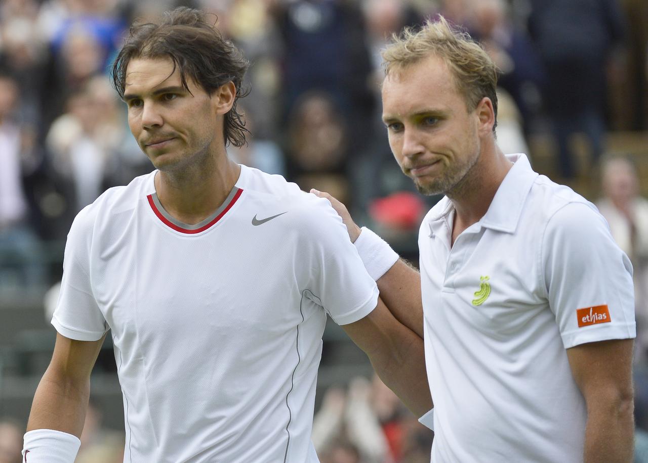 Nadal, consolé par Steve Darcis, n'avait jamais été sorti d'entrée en Grand Chelem. [REUTERS - Toby Melville]