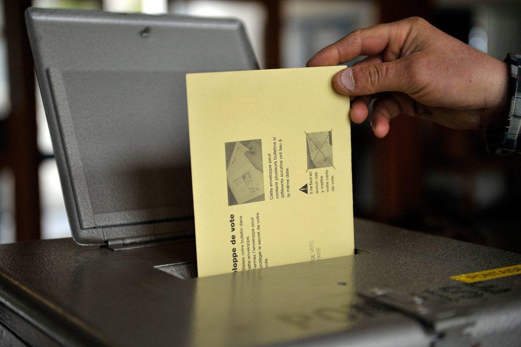 Une personne dépose son bulletin de vote dans une urne, en ville de Lausanne, ce dimanche 13 mars 2011, lors des élections communales. [Keystone - Dominic Favre]