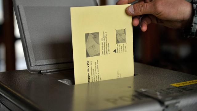 Une personne dépose son bulletin de vote dans une urne, en ville de Lausanne, ce dimanche 13 mars 2011, lors des élections communales. [Keystone - Dominic Favre]