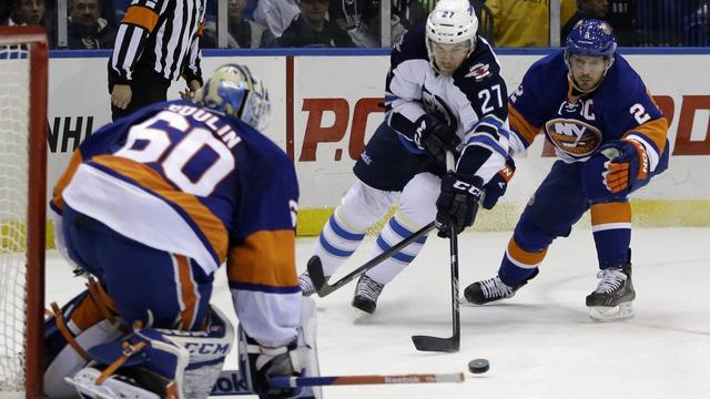 Mark Streit (2) tente de stopper Eric Tangradi (27), l'ailier de Winnipeg. [Kathy Willens]