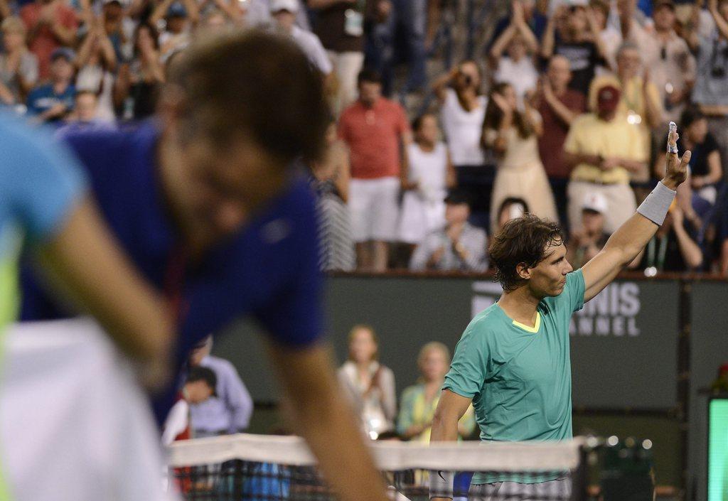 epa03625054 Rafael Nadal of Spain (R) waves to the crowd while Rodger Federer of Switzerland (L) packs up after winning in second set during the BNP Paribas Open tennis tournament in Indian Wells, California, USA, 14 March 2013. EPA/JOHN G. MABANGLO [John G.Mabanglo]