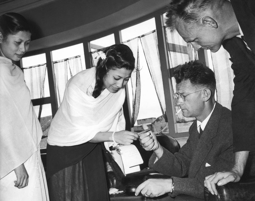 L'un des membres de l'expédition suisse dans l'Himalaya en 1956, Fritz Luchsinger, signe des autographes dans la capitale népalaise Katmandou. [KEYSTONE]