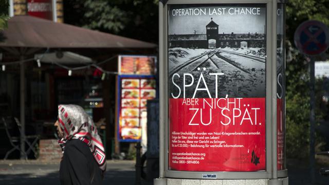Les affiches montrent une photo de l'entrée du camp d'Auschwitz. [Johannes Eisele]
