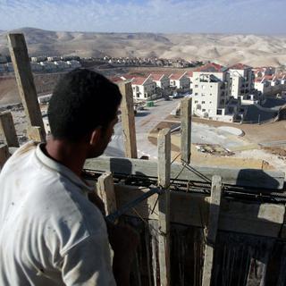 Un Palestinien travaille à la construction de nouvelles maisons dans la colonie juive de Maale Adumim, à l'est de Jérusalem. [AHMAD GHARABLI]