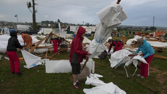 Des bénévoles commencent à dégager les lieux de la Fête fédérale de gymnastique ravagés par l'orage. [KEYSTONE - Gian Ehrenzeller]