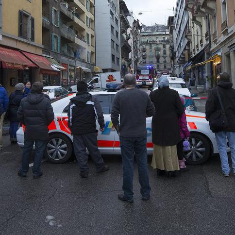 Une voiture de police entourée de personnes du quartier des Pâquis, Genève. [Keystone - Salvatore Di Nolfi]